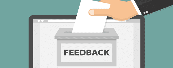 A hand placing a card into a feedback box.