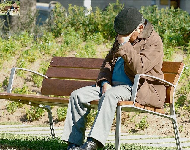 Old man worried on bench