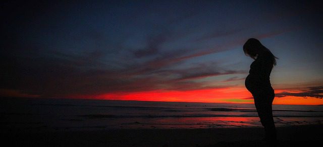 Pregnant woman at sunset