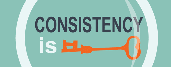 A magnifying glass looking upon a sign that says "Cosistency is key".