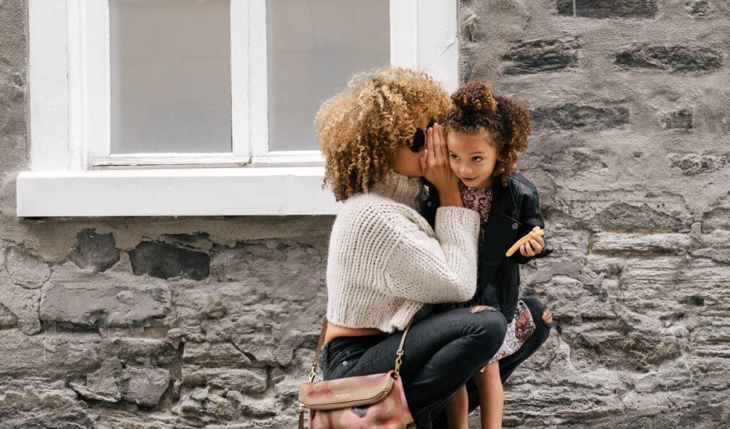 Woman whispering to child