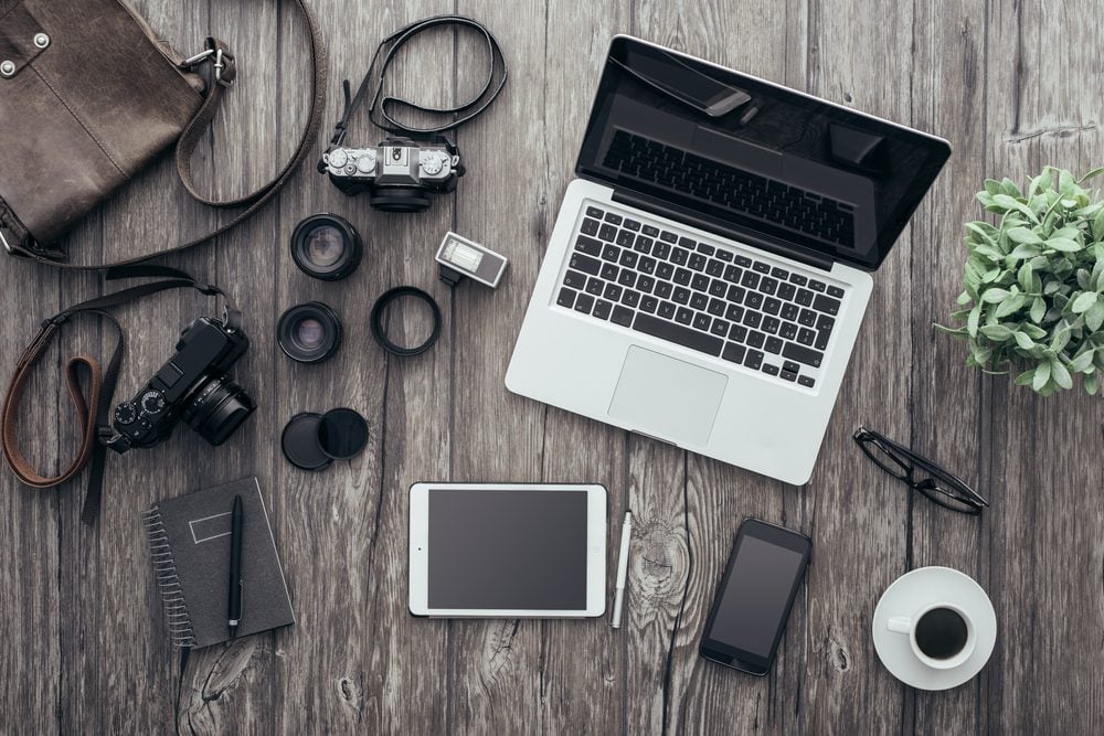 Laptop and photography tools on wooden table 