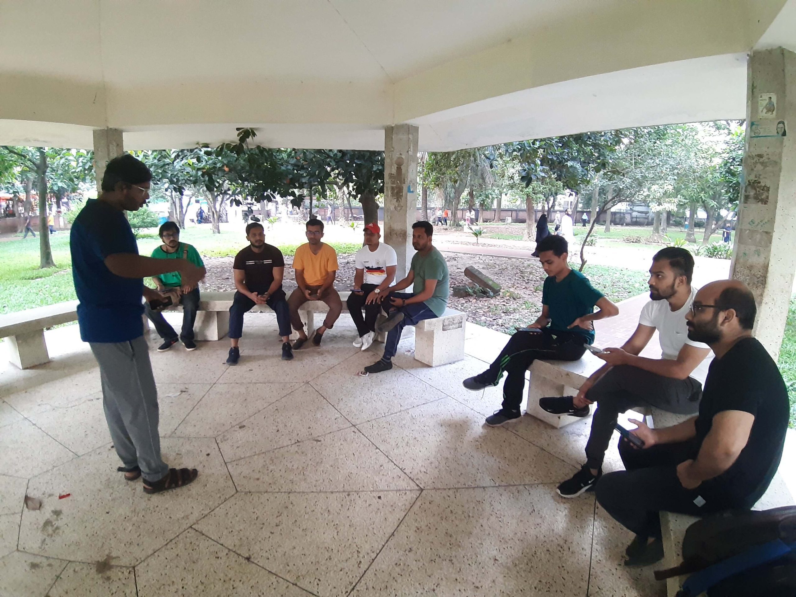 group of men sitting and listening to one standing man at the Divi Dhaka meetup