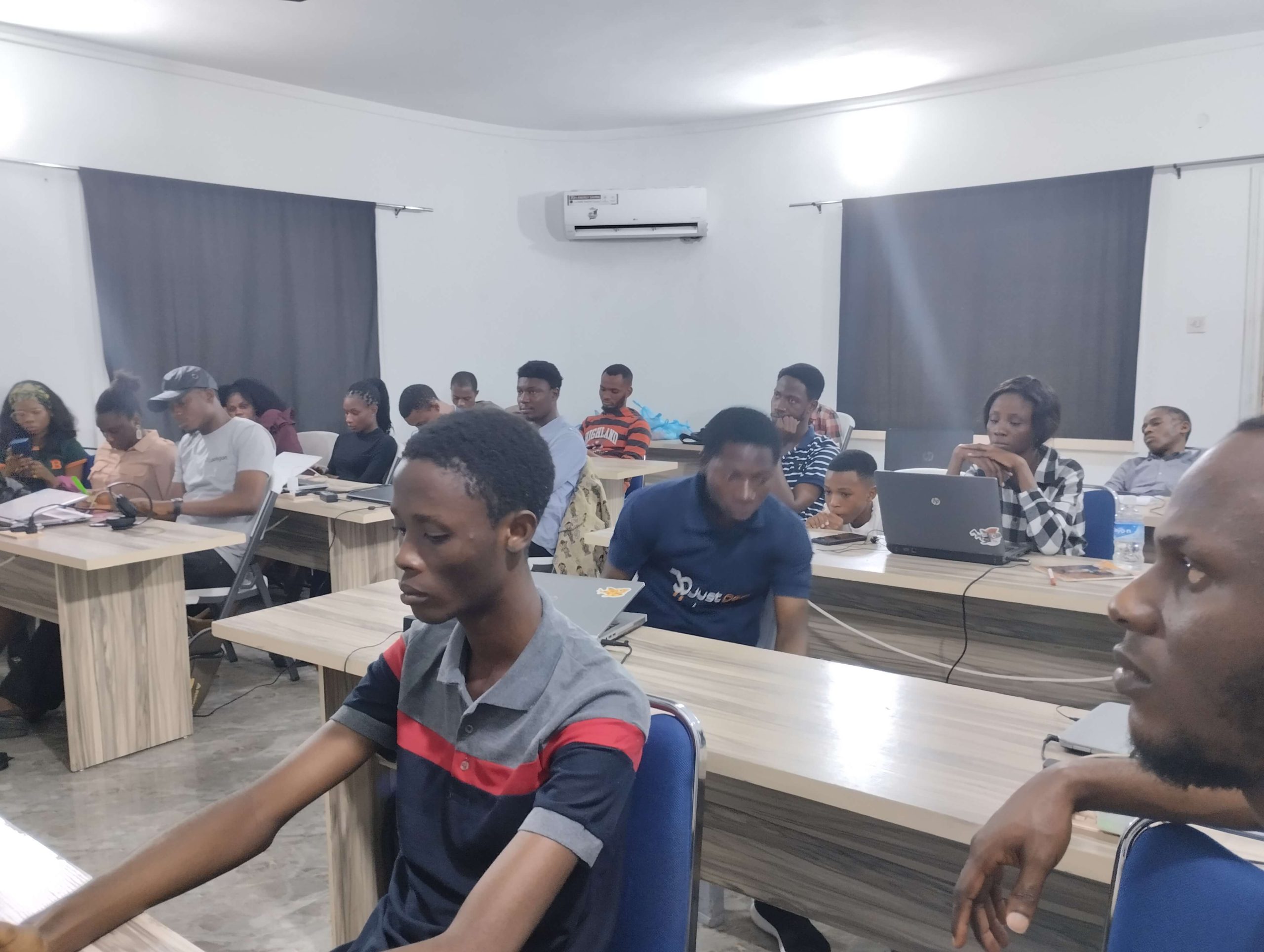 Divi Warri people sitting at tables and learning.