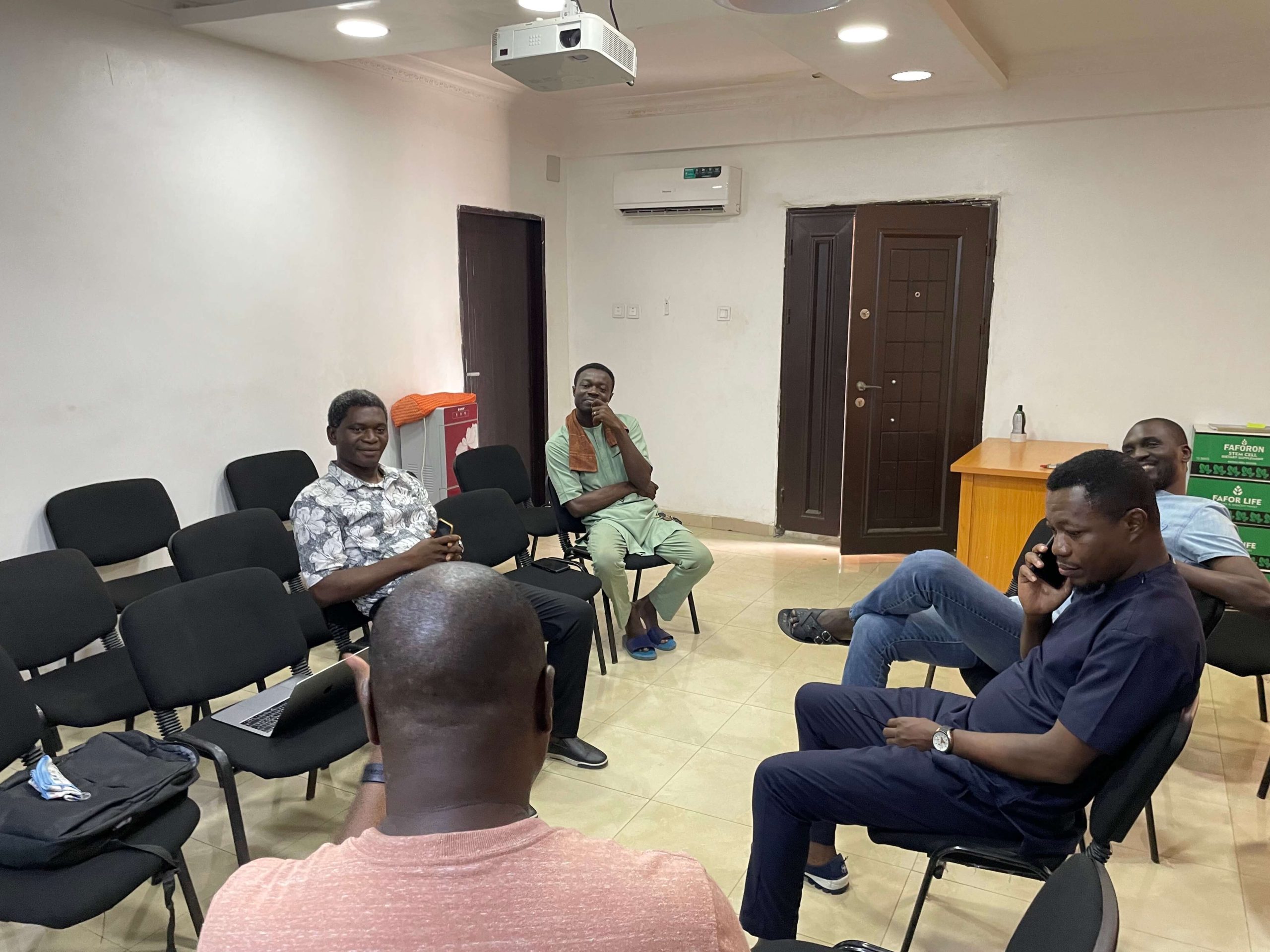 گروهی از نیجریه ای ها در یک دایره نشسته اند و در مورد دیوی بحث می کنند